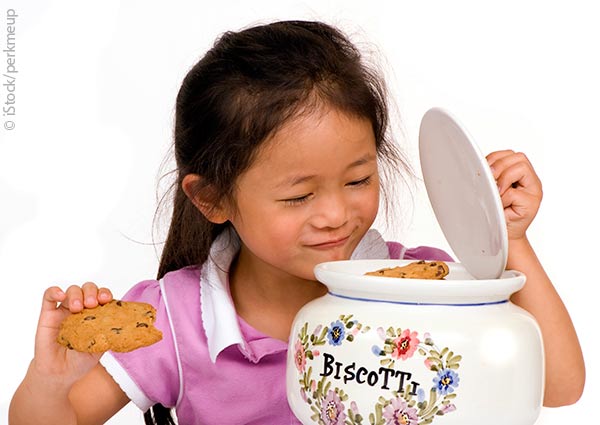 child taking cookie from cookie jar