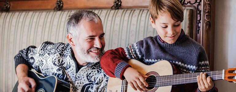 father playing guitar with son
