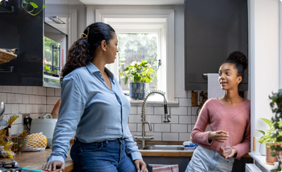 A mom and daughter talking in their kitchen