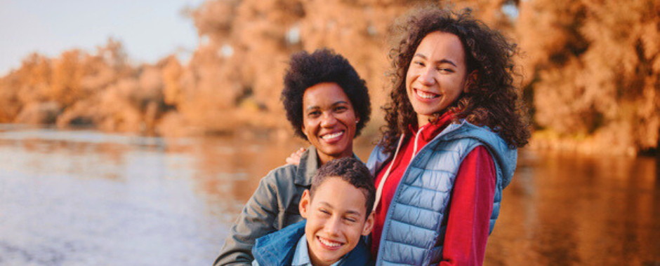 African American mother with her two simling sons hugging and smiling