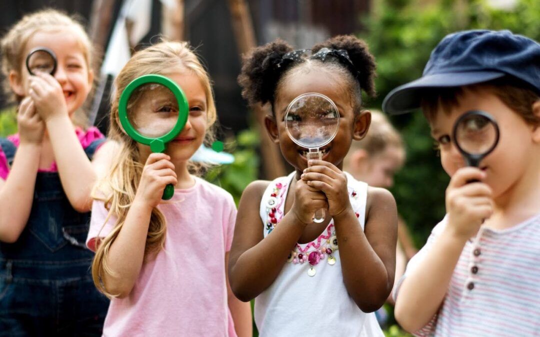 Group of kindergarten kids friends holding magnifying glass